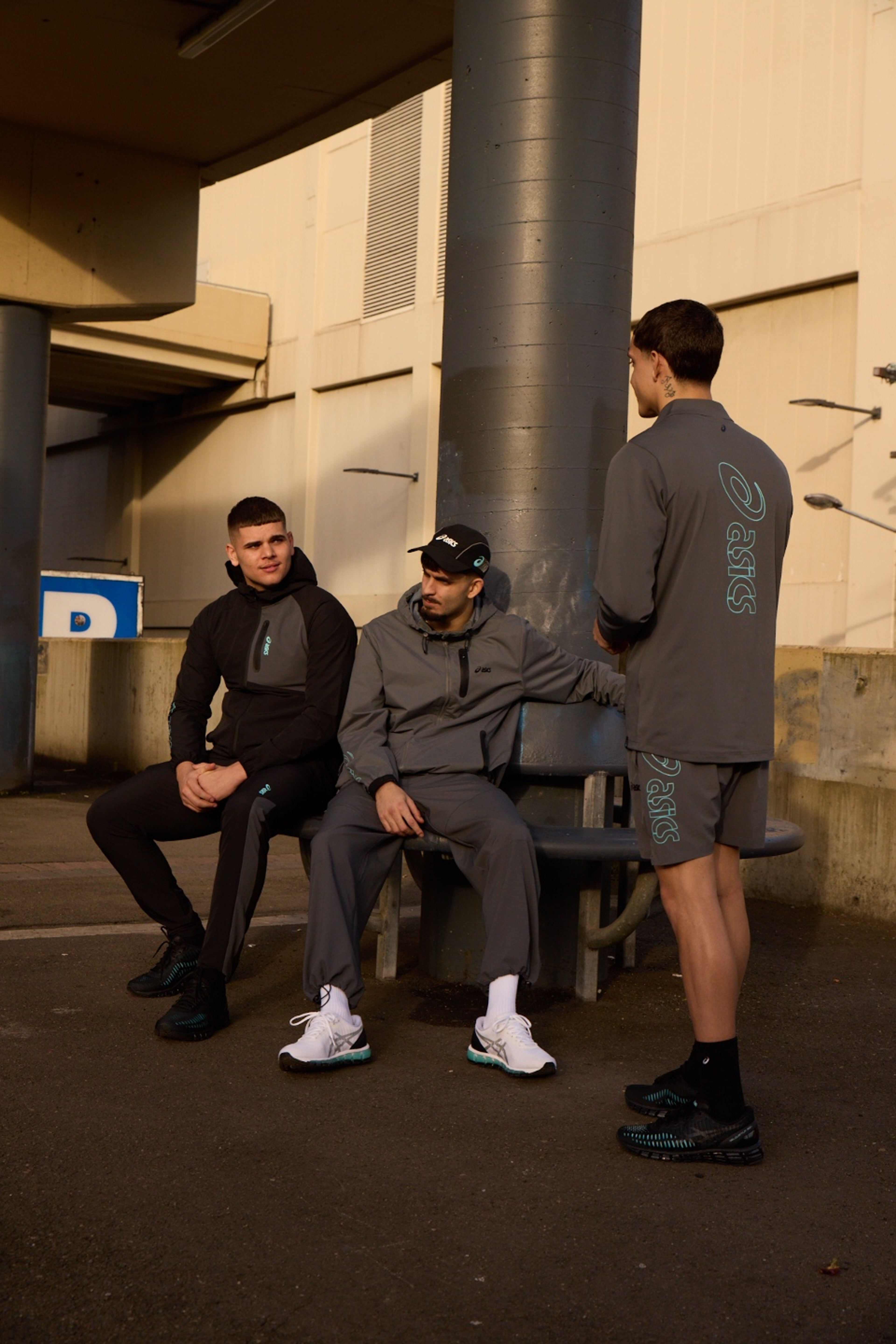 Group of friends in ASICS GEL-Quantum 360 shoes standing against a concrete pillar