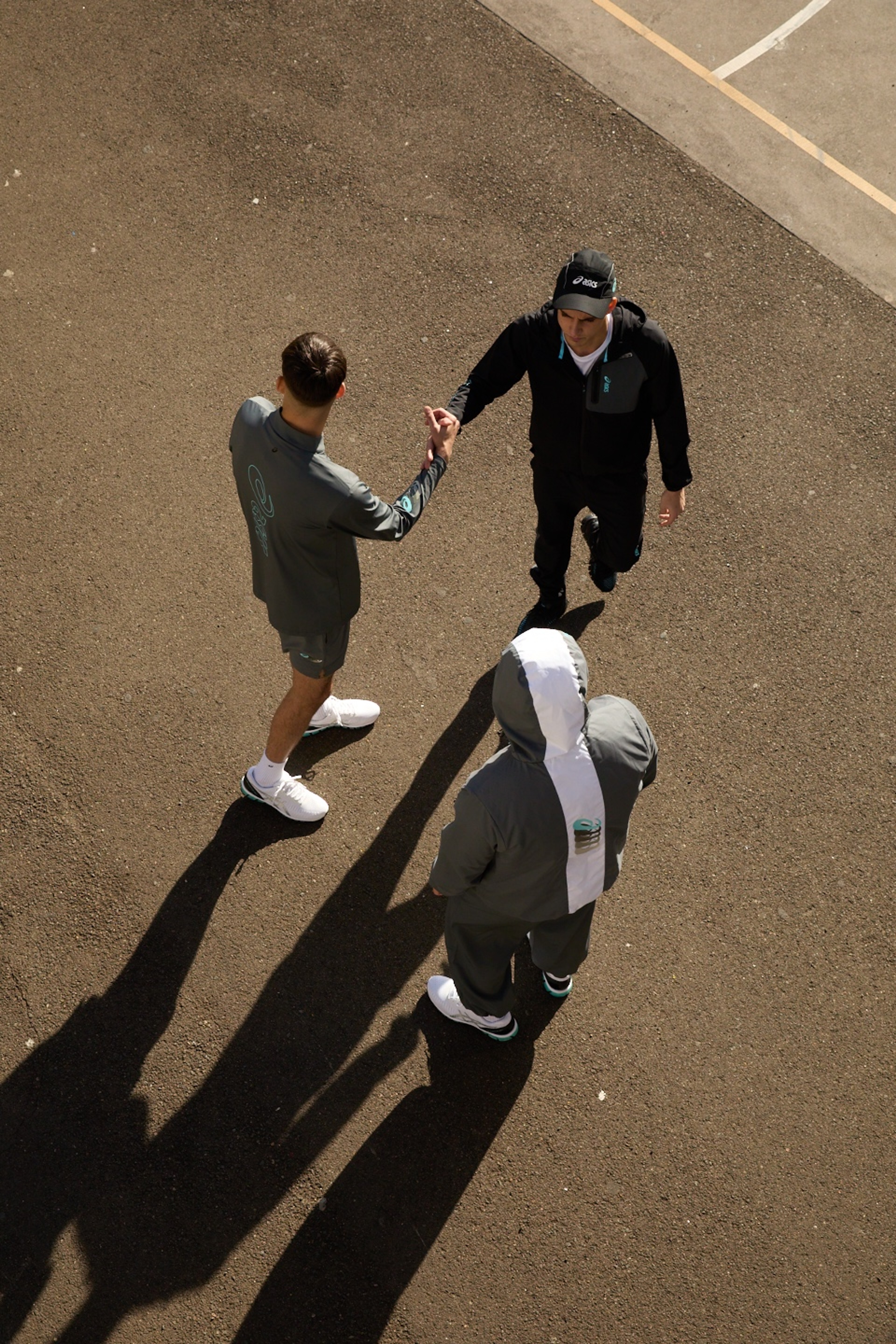 Two friends greeting each other on the street in ASICS GEL-Quantum 360 shoes