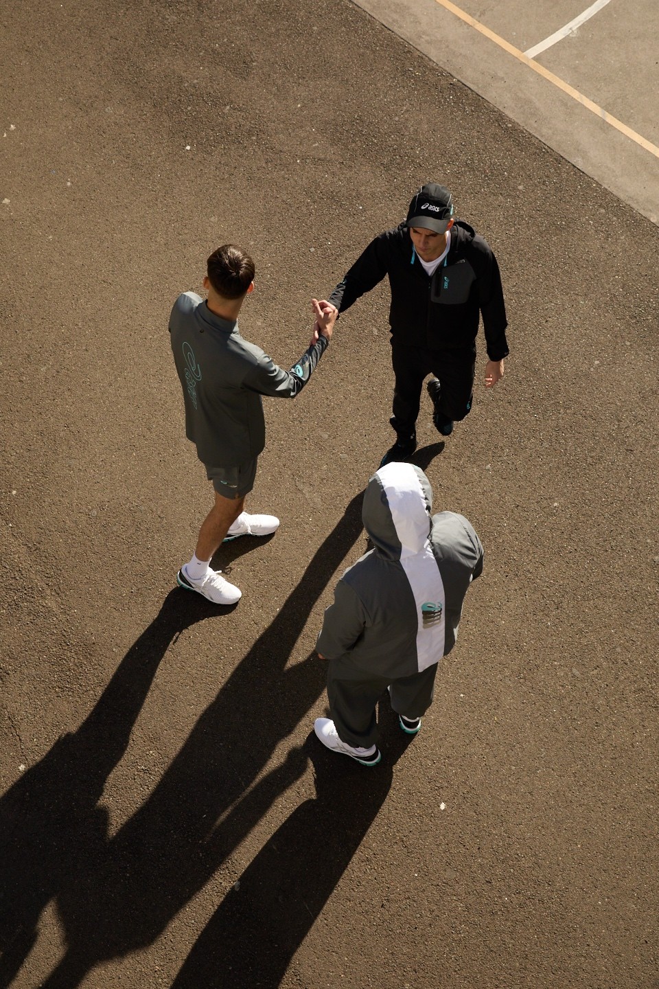 Two friends greeting each other on the street in ASICS GEL-Quantum 360 shoes