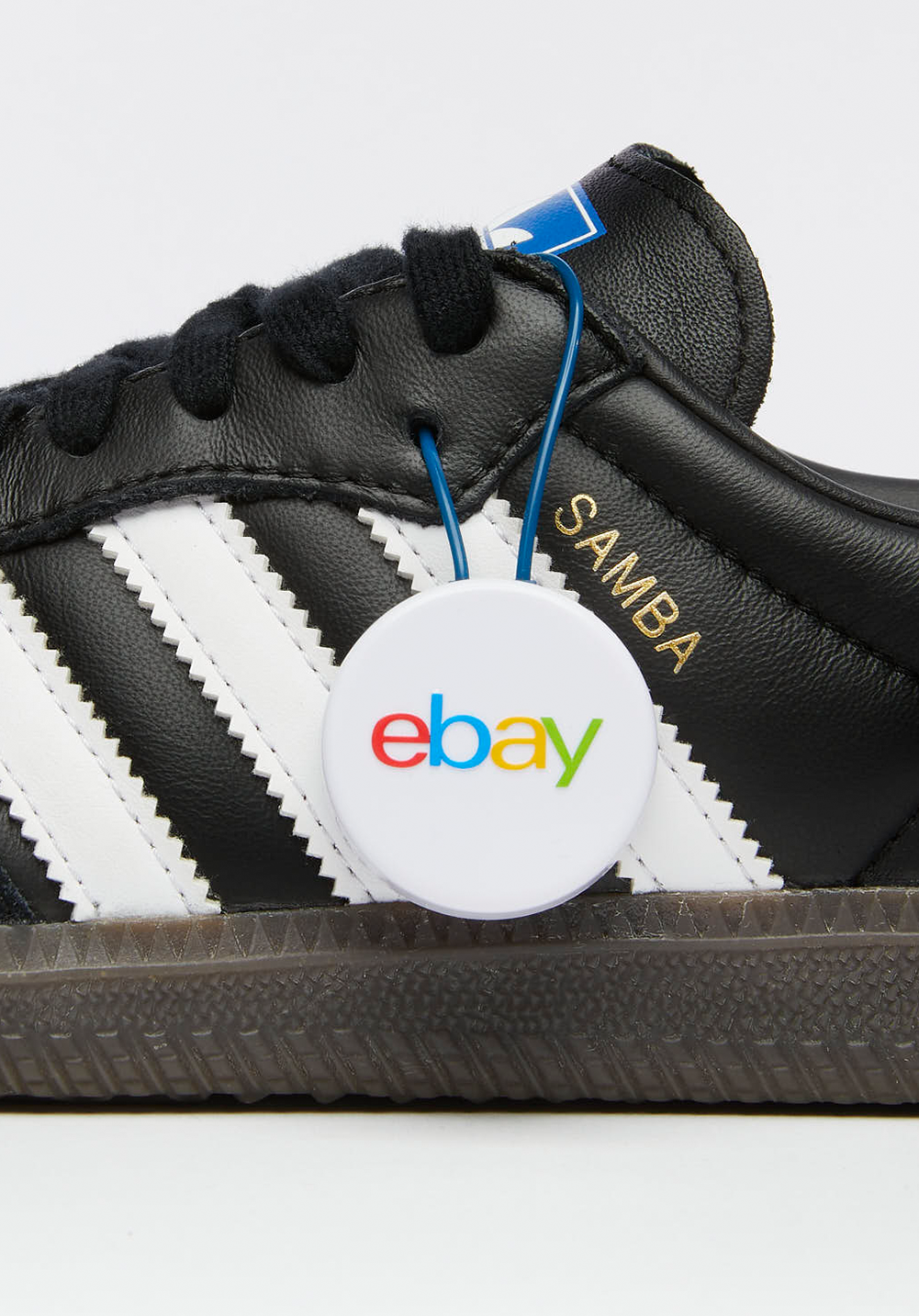Black Adidas Samba shoe with white stripes and an eBay authentication tag.