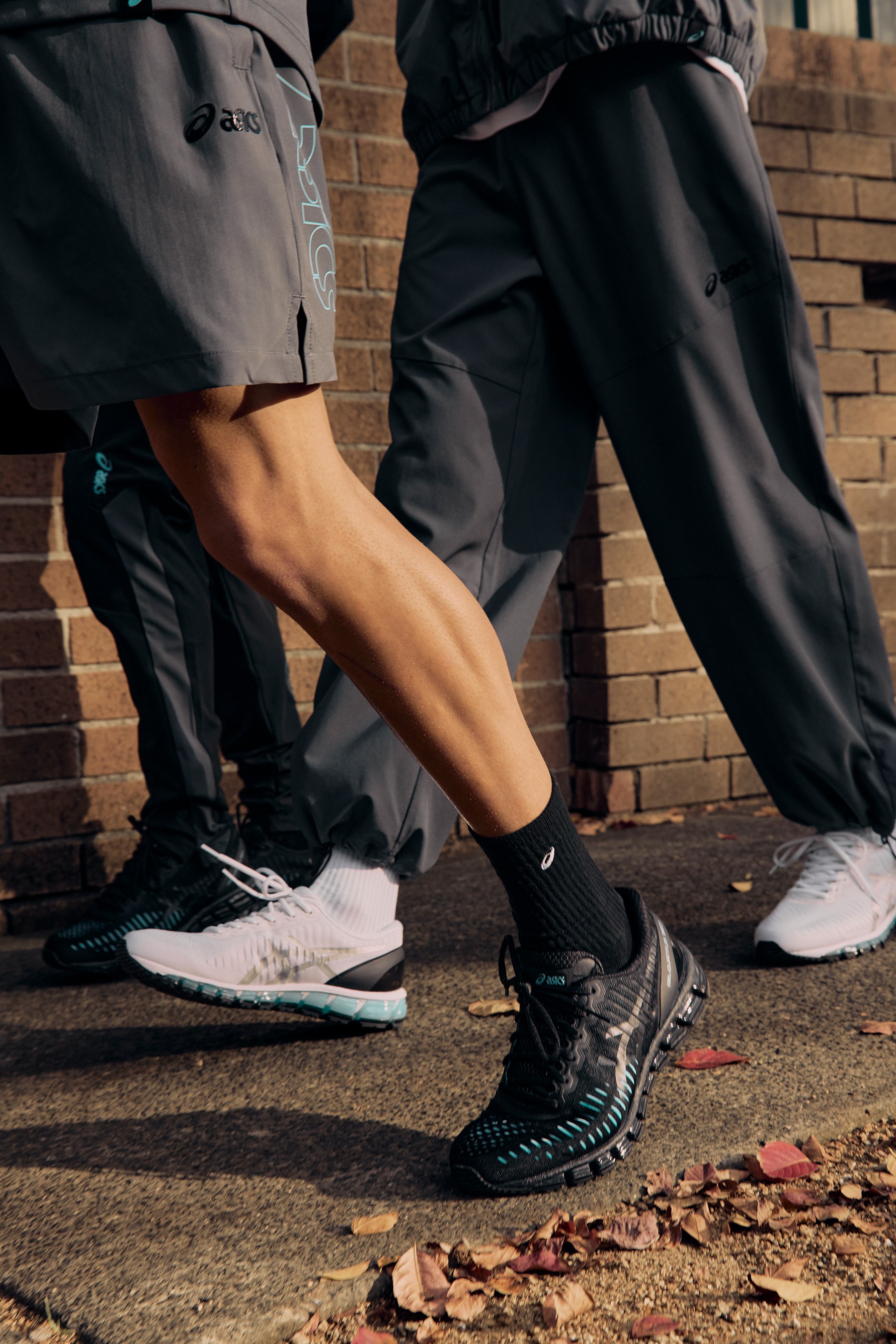 Close-up of a seated figure wearing white ASICS GEL-Quantum 360 trainers