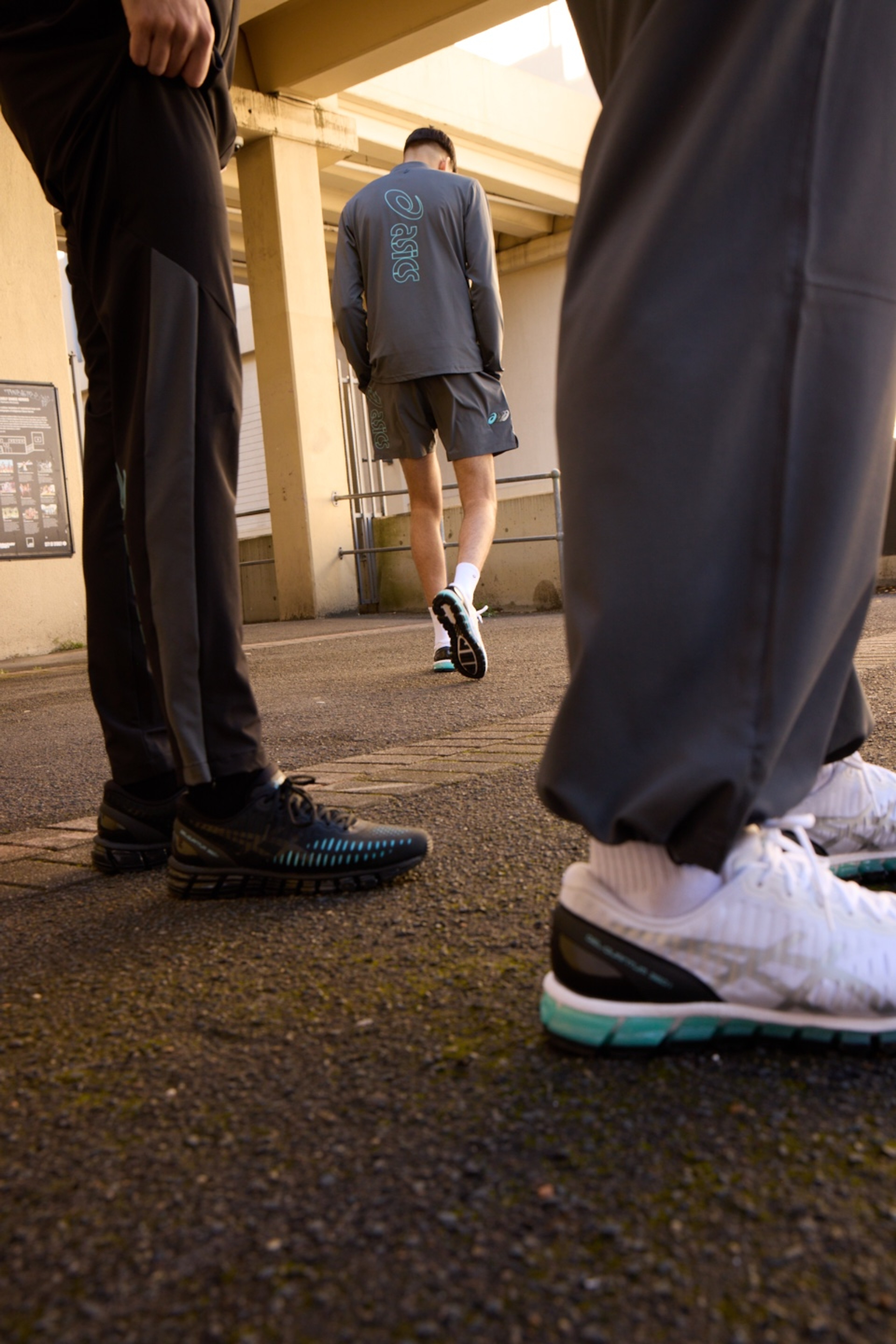 Street-level shot of legs and ASICS GEL-Quantum 360 shoes mid-stride