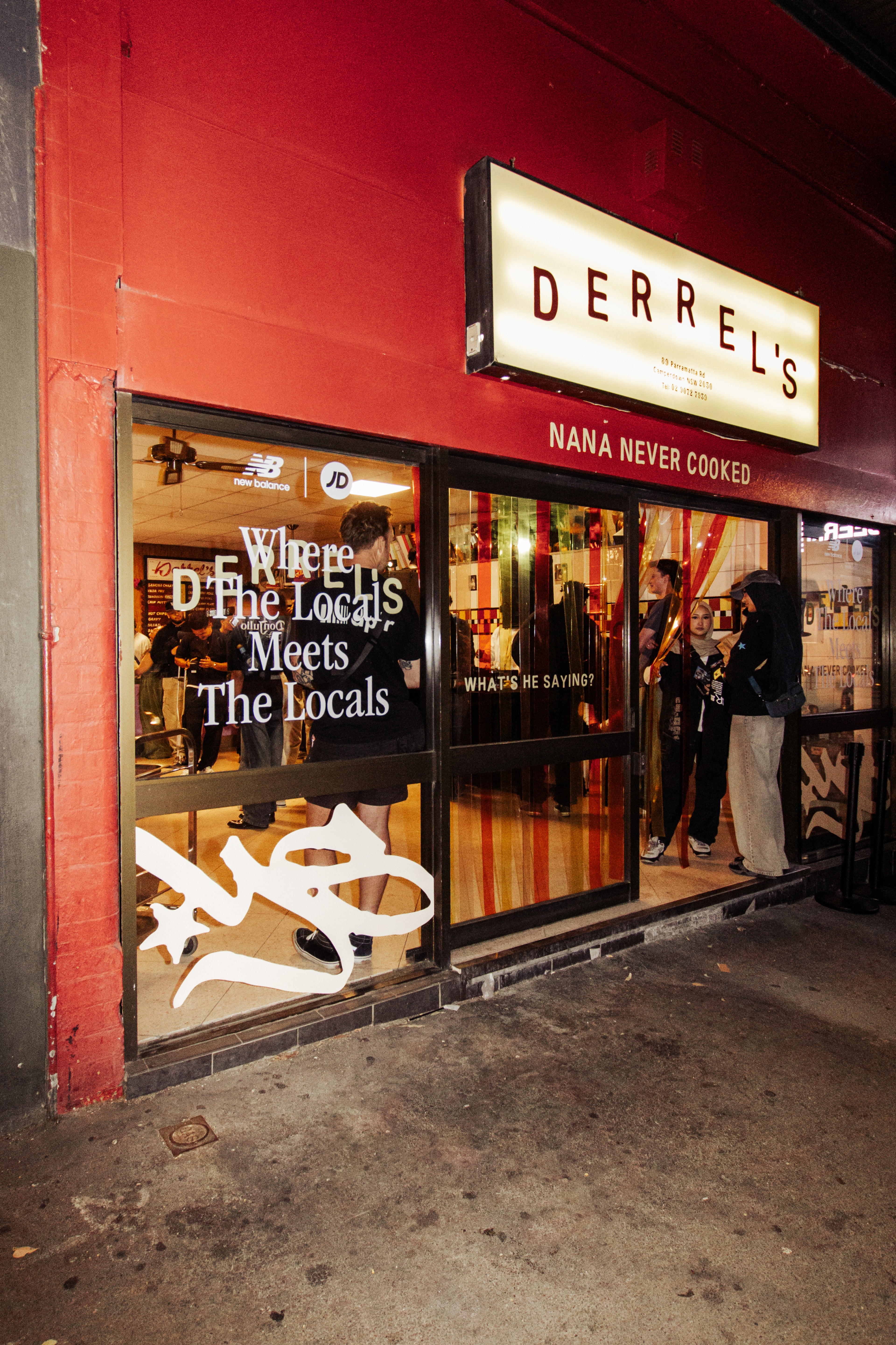 Red-fronted Derrels storefront at street level with illuminated menu display and signage