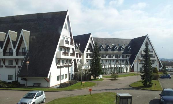 A large chalet-style hotel with steep dark roofs and white walls beside a landscaped car park in Bracknell.
