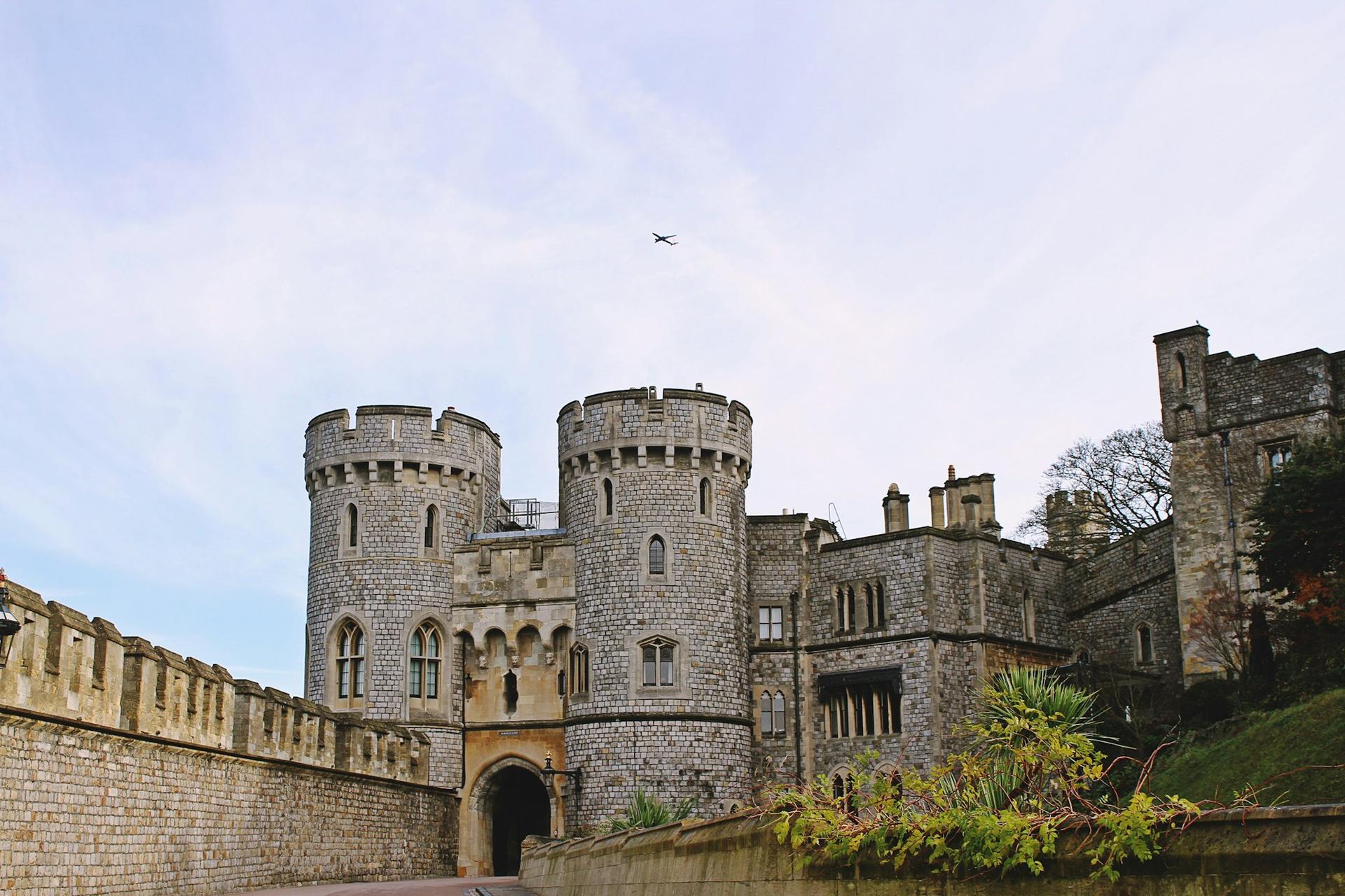 The twin drum towers of the Norman Gate at Windsor Castle under a pale sky.