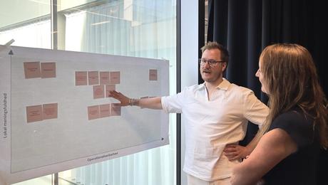 Mand og kvinde står ved planche, der er sat op på rude