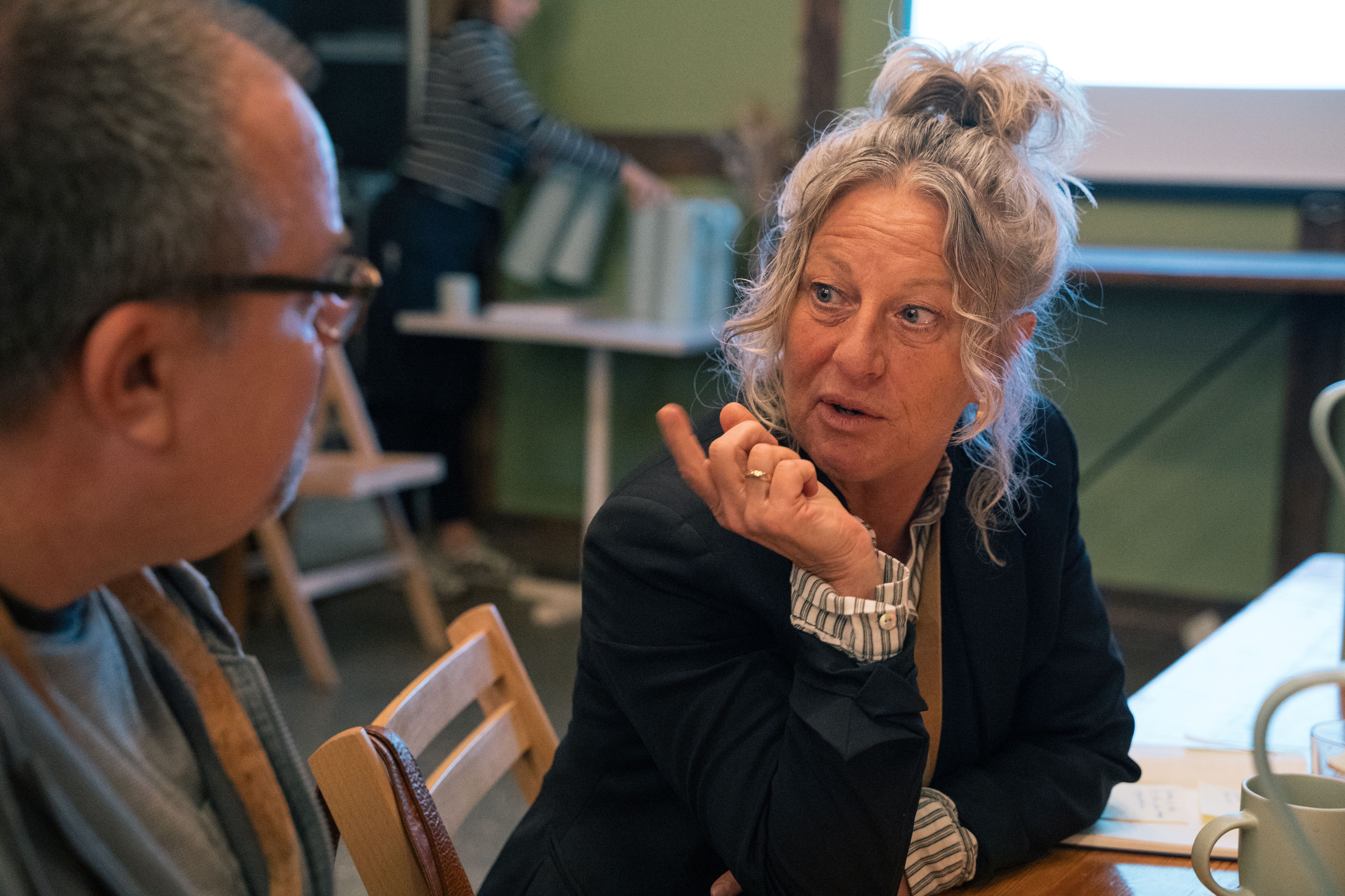 Kvinde og mand sidder i drøftelse ved bord