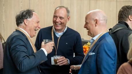 Tre direktører griner og drikker kaffe til AlmenKompas-kickoff