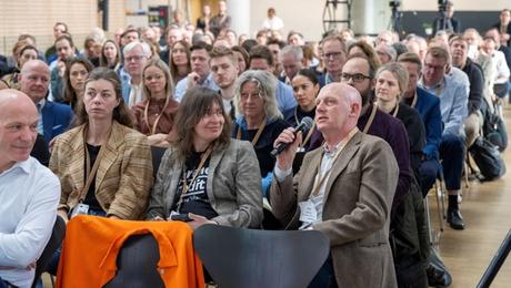 Sal med mange mennesker siddende til kickoff i april 2024