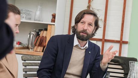 Mand sidder i café og taler