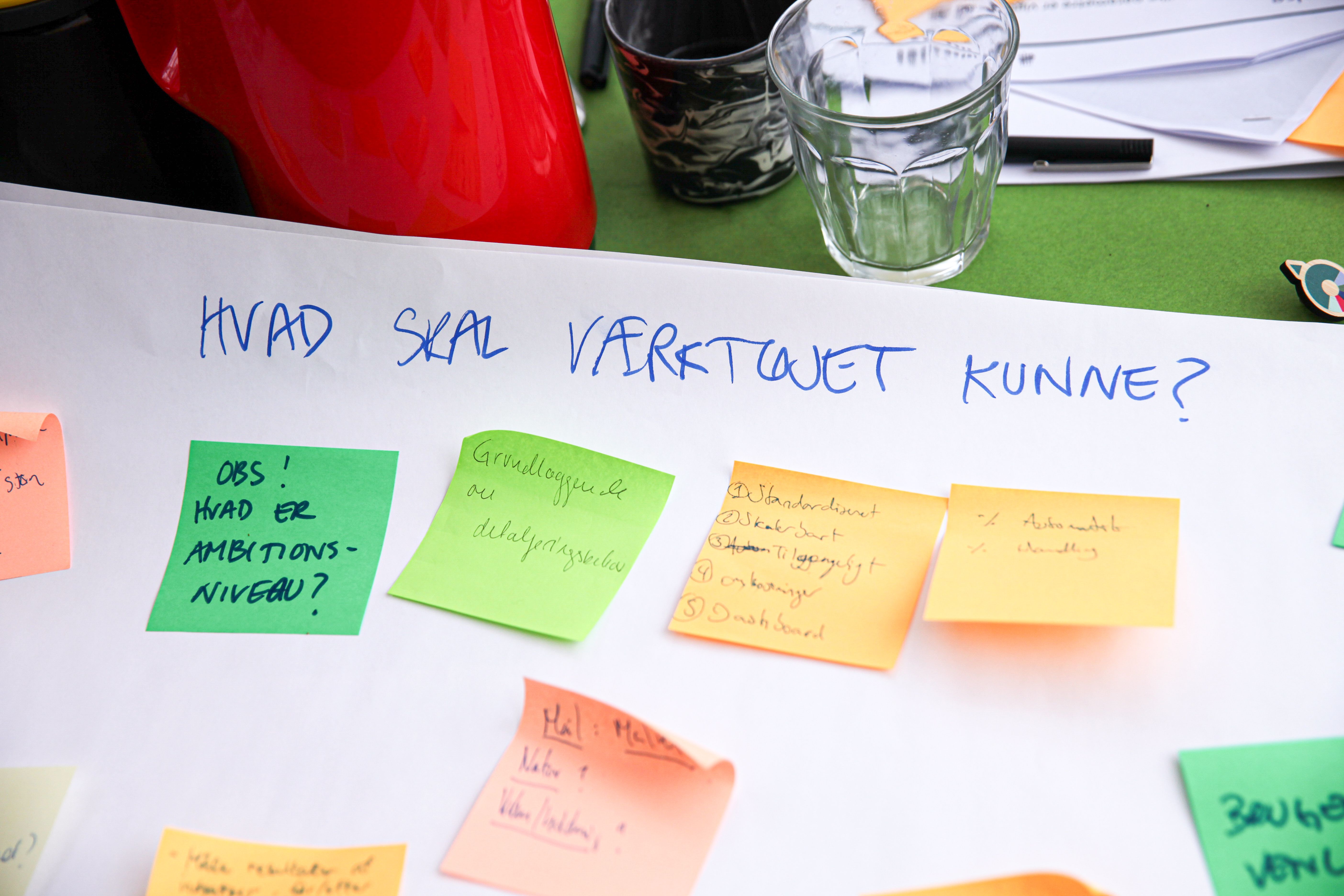 Farverige notesedler på planche, hvor der står "Hvad skal værktøjet kunne?"