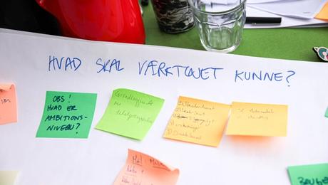 Farverige notesedler på planche, hvor der står "Hvad skal værktøjet kunne?"