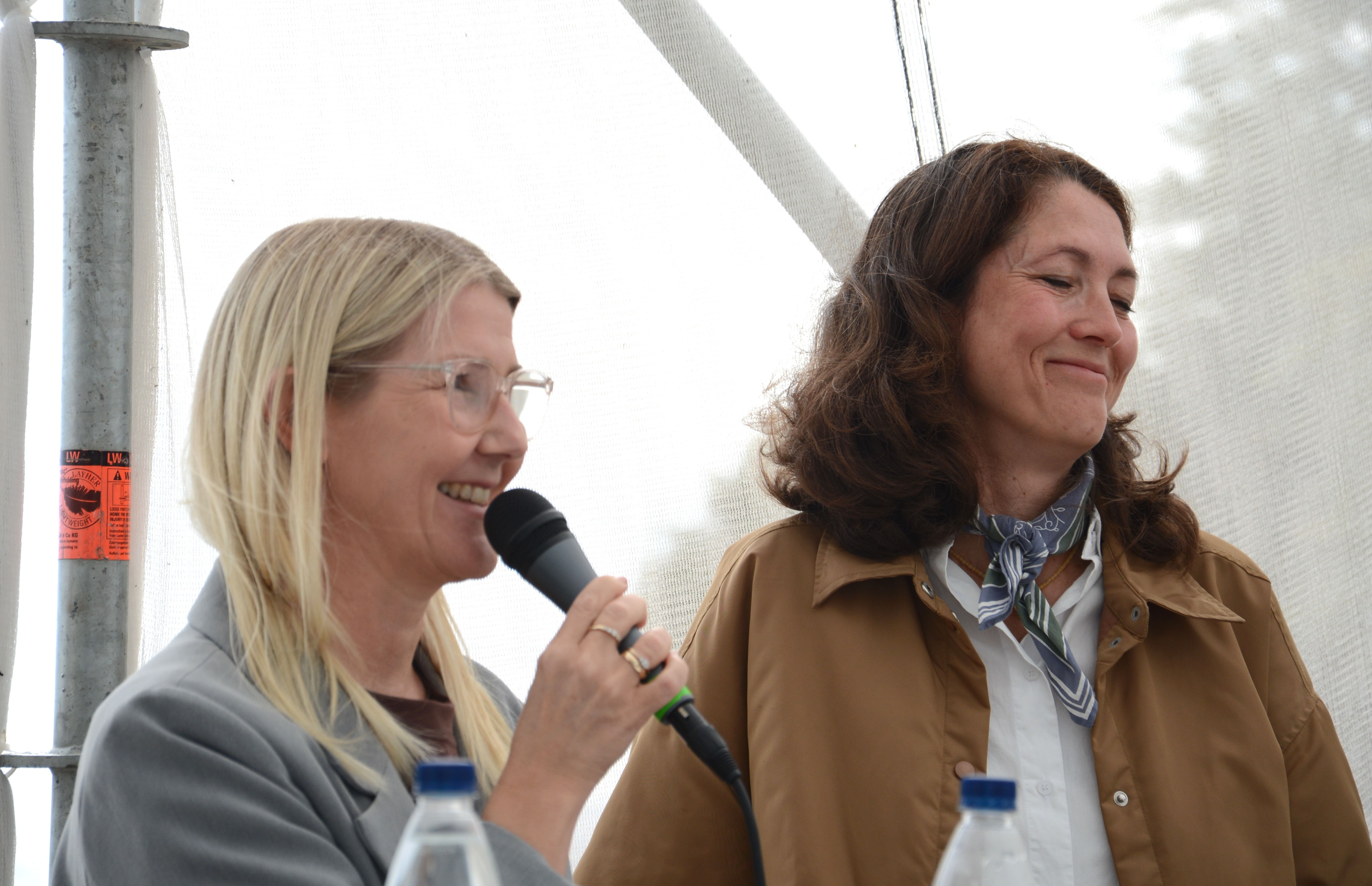 Closeup af to kvinder. Den ene taler i mikrofon.