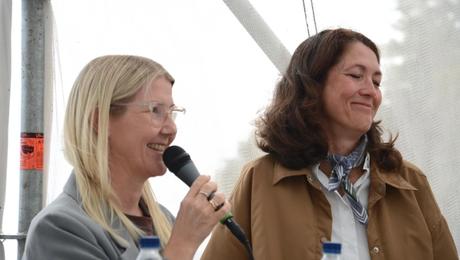 Closeup af to kvinder. Den ene taler i mikrofon.