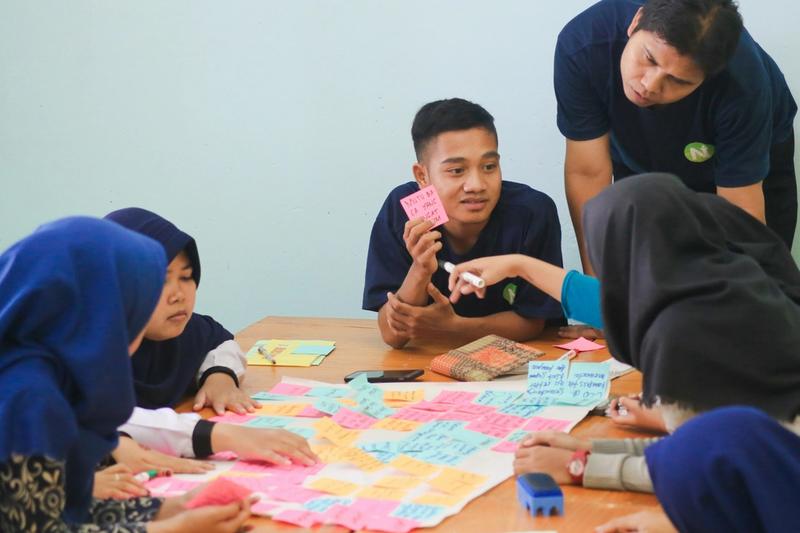 High school students collaborating on a hands-on building project in a workshop classroom at a project-based high school in St. Petersburg, Florida