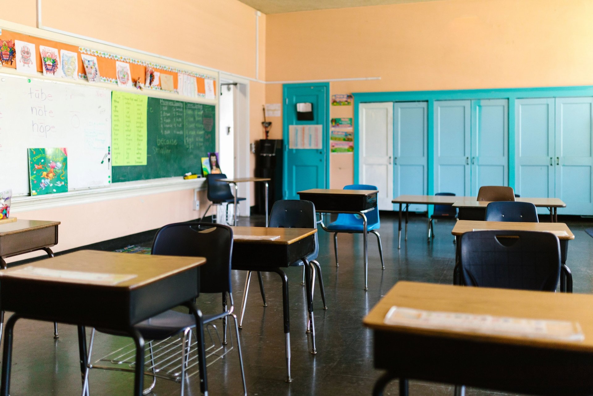 Empty classroom with desks, blackboard and educational materials