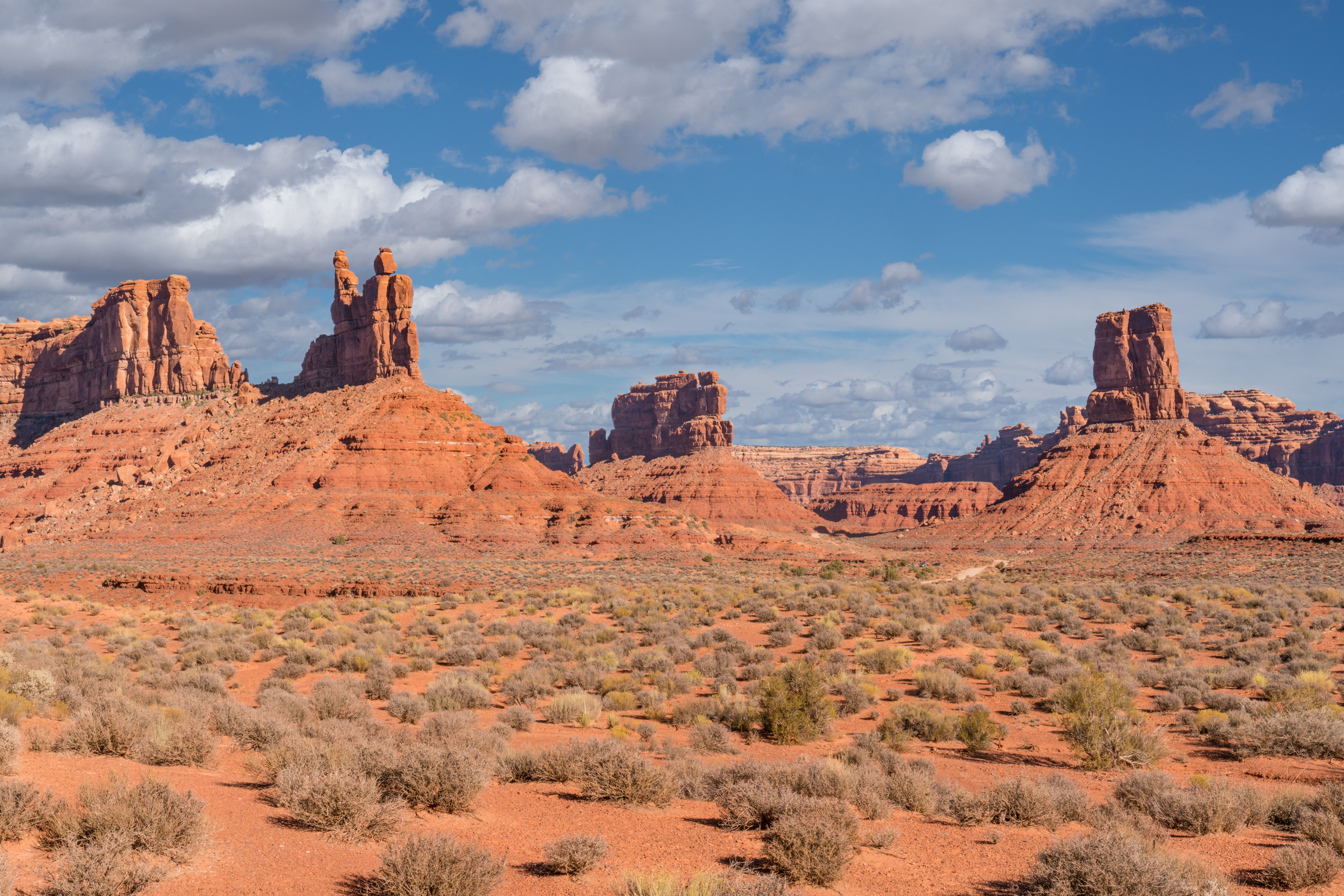 Red sandstone formations at Bears Ears National Monument under a bright blue sky with scattered clouds.