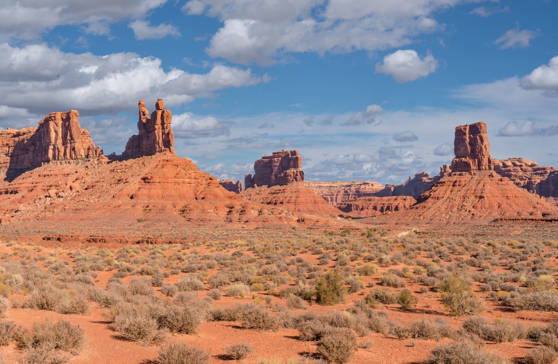 Red sandstone formations at Bears Ears National Monument under a bright blue sky with scattered clouds.