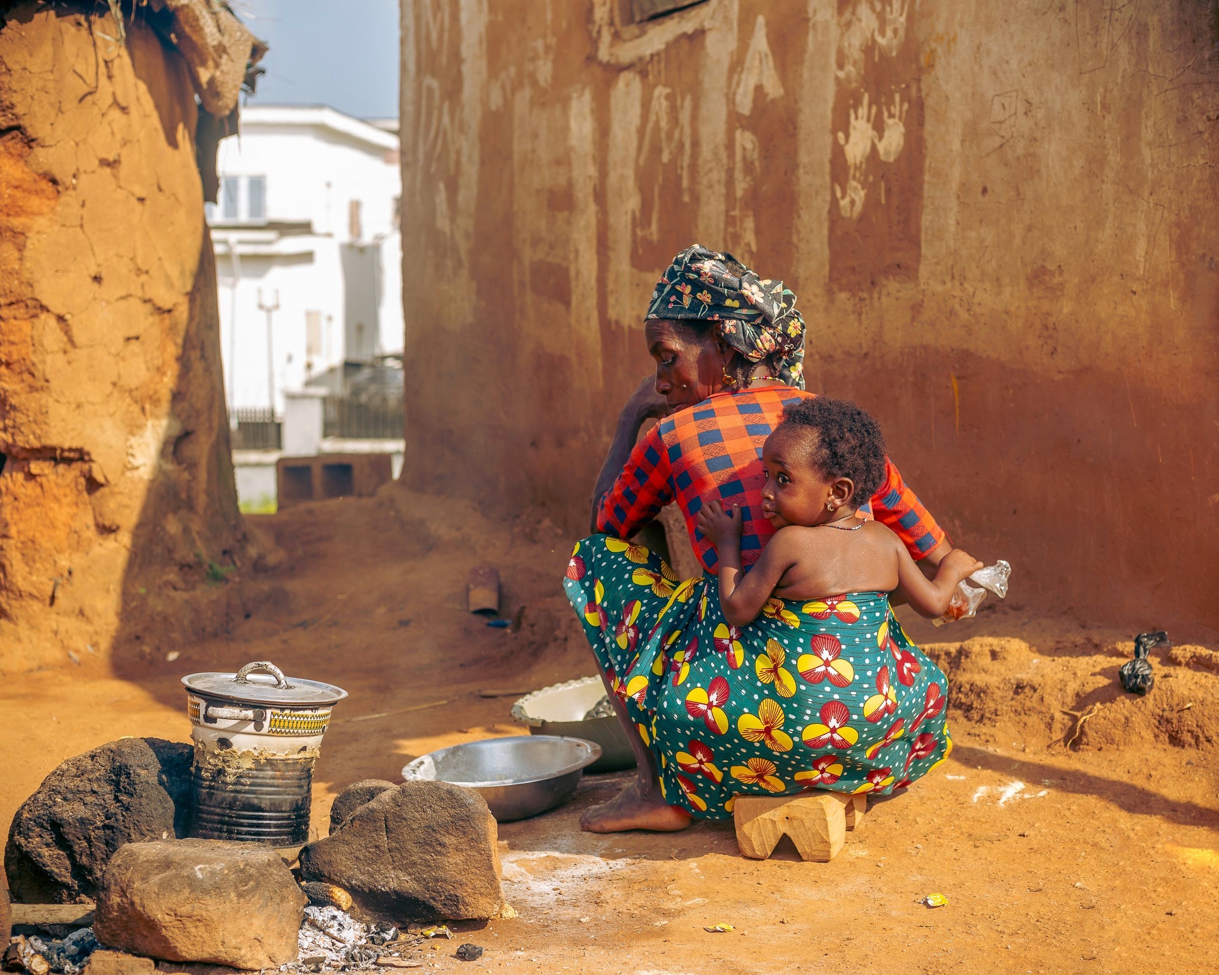 Traditional outdoor cooking scene with African mother and child in a rural village