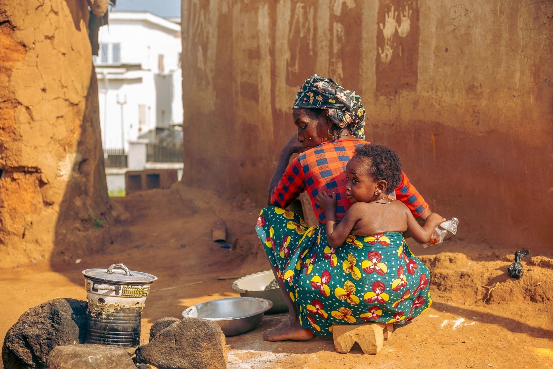 Traditional outdoor cooking scene with African mother and child in a rural village
