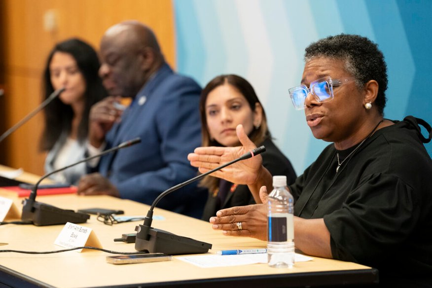 Panel discussion, with one woman gesturing while speaking.