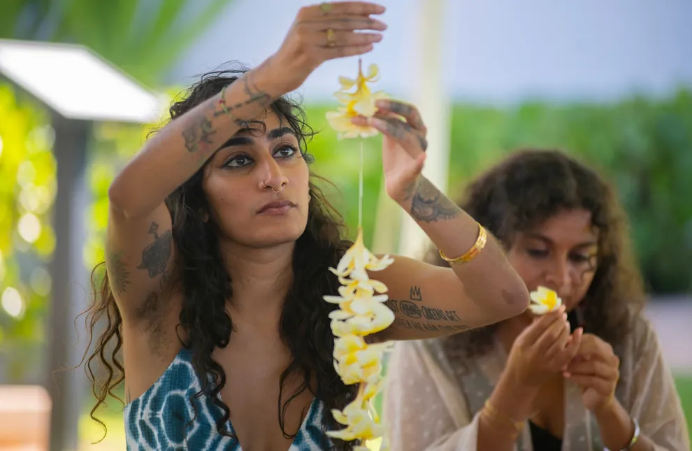 Two women making a lei