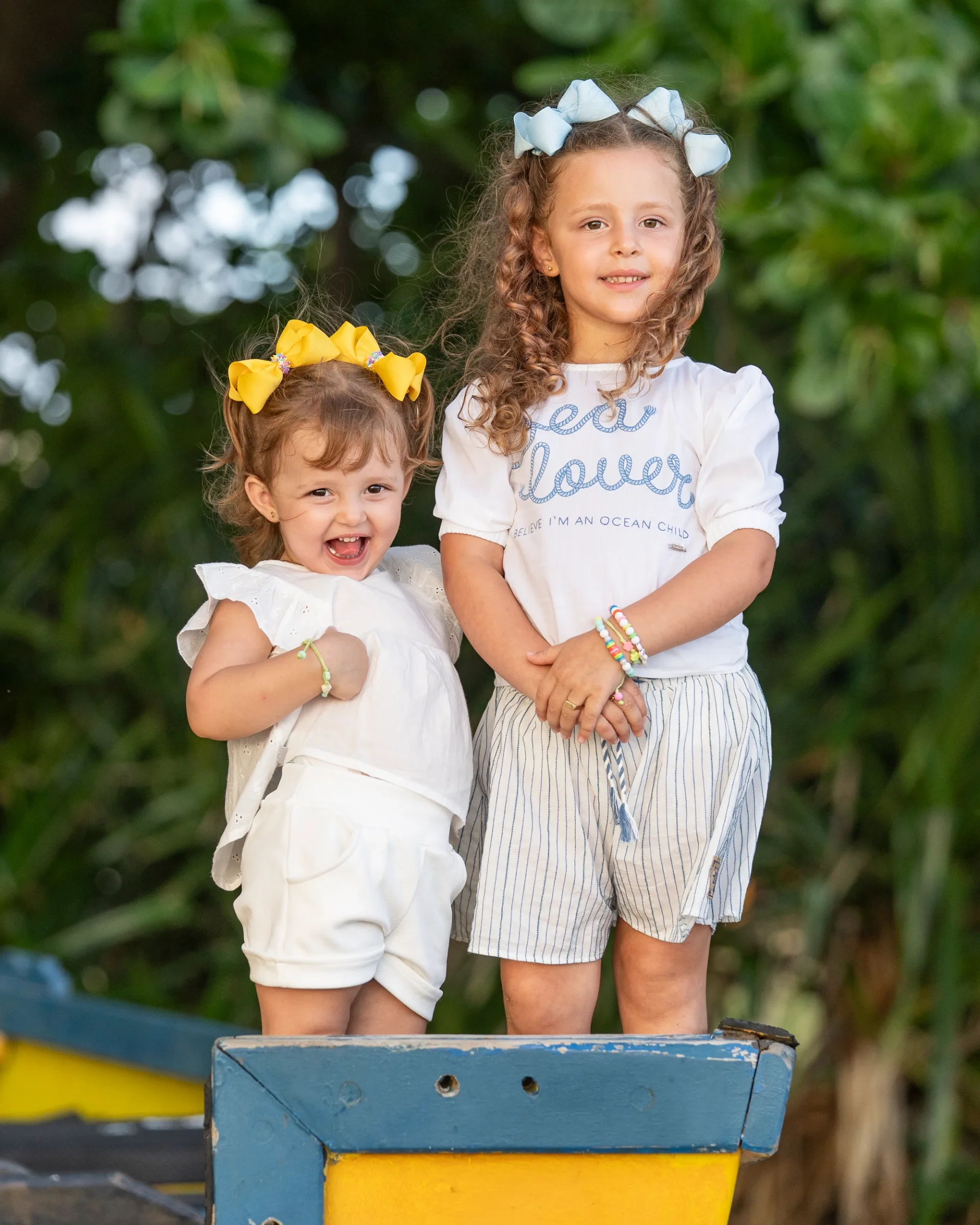 Two young sisters smiling together outdoors