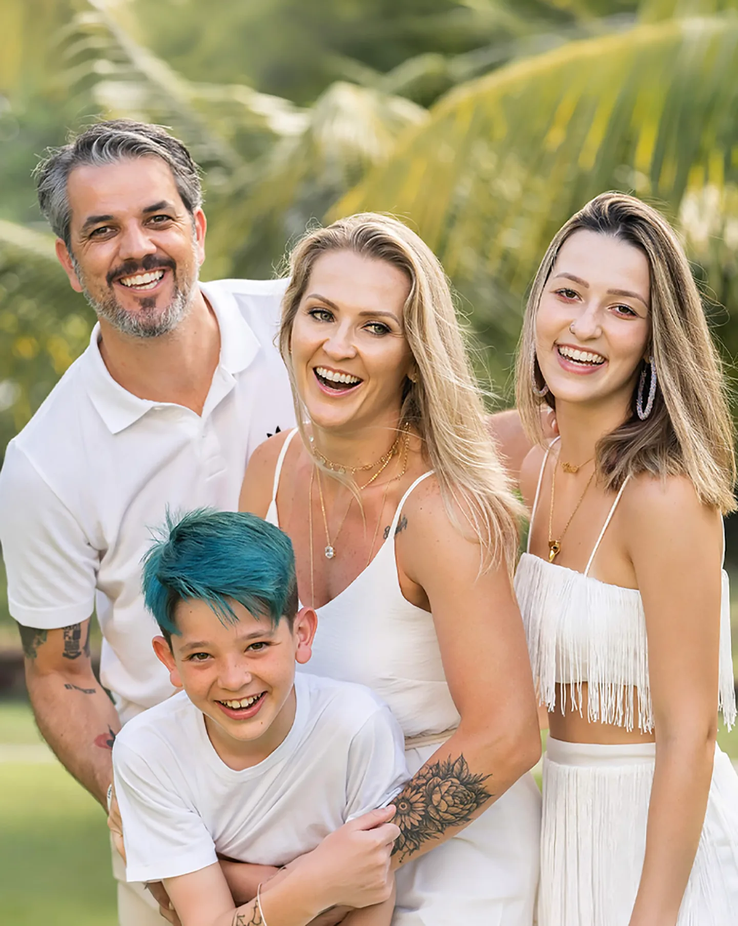 A smiling family of four photographed together outdoors