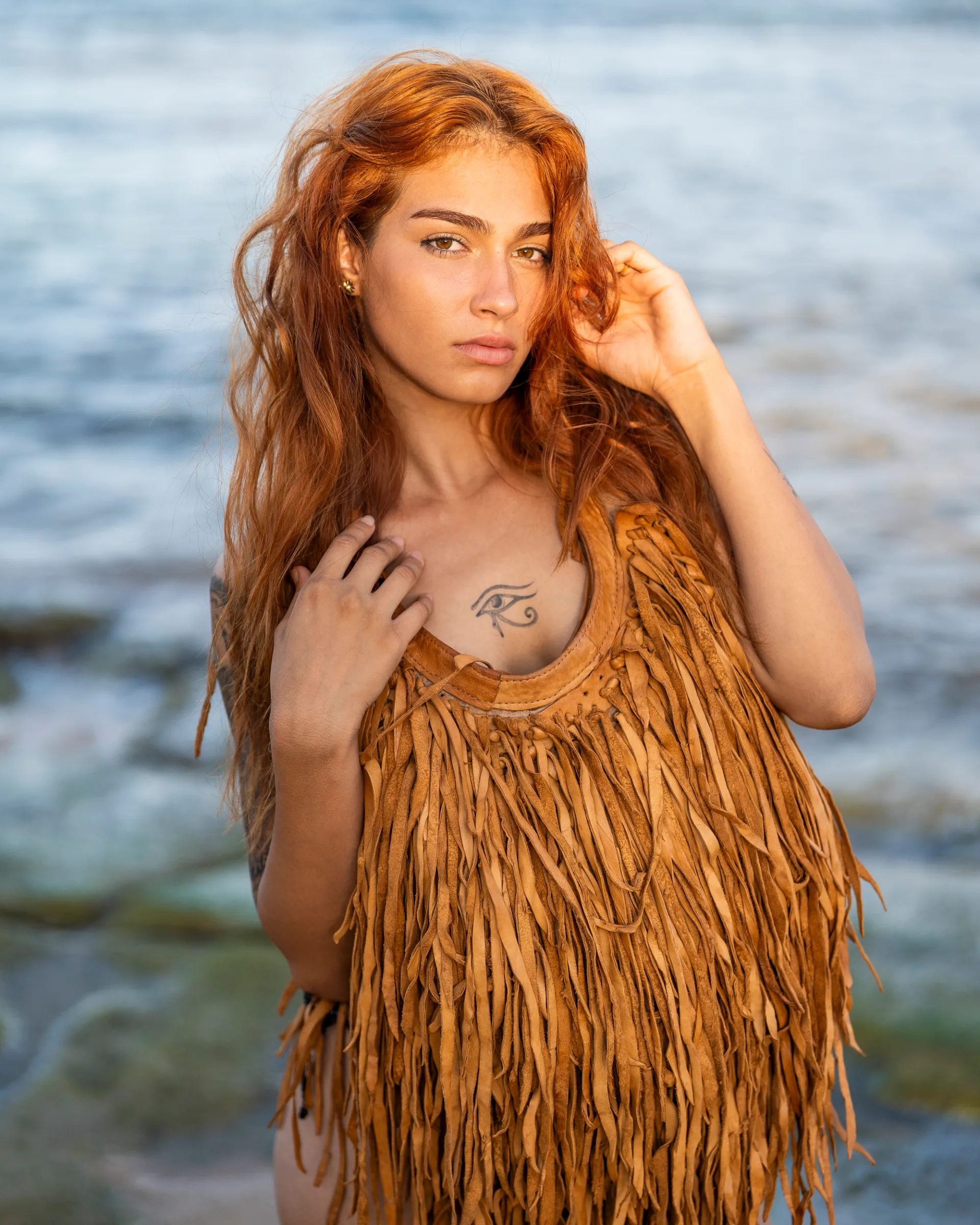 Fashion portrait by the water, combining warm tones, texture and natural movement.