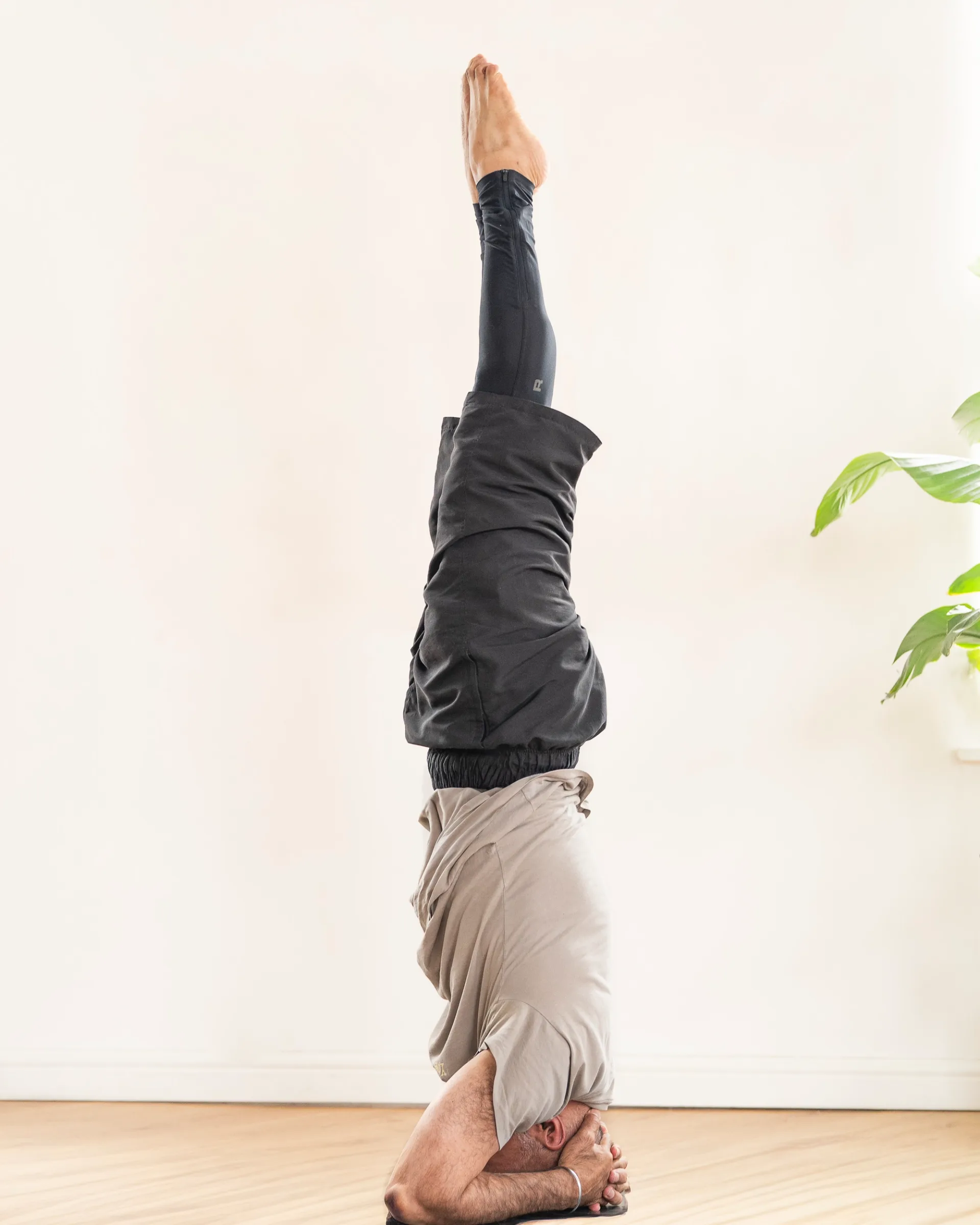 Yogi teacher portrait holding a deep backbend wearing casual clothes