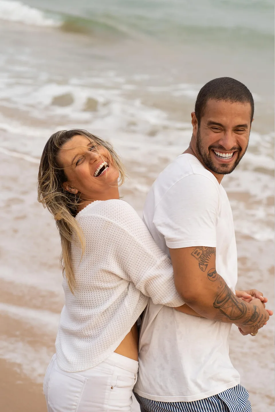 A couple laughing together at the beach