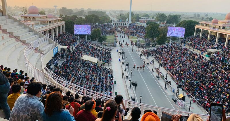 The Wagah-Attari Border Beating Retreat ceremony — the BSF (India) and Pakistan Rangers lower both countries' flags simultaneously at sunset every day; started in 1959 as a solemn military ritual, evolved into a theatrical nationalist performance; free entry; winter timings 4:15pm, summer 5:15pm; arrive 1.5–2 hours before