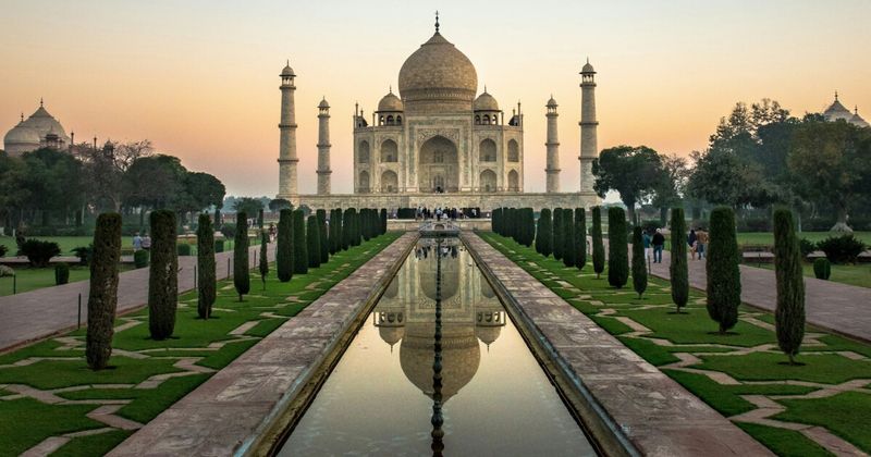 The Taj Mahal reflected in its garden pool at dawn in Agra — built 1632–1653 by Mughal Emperor Shah Jahan as a mausoleum for Mumtaz Mahal and one of the few buildings on earth that exceeds every photograph ever taken of it