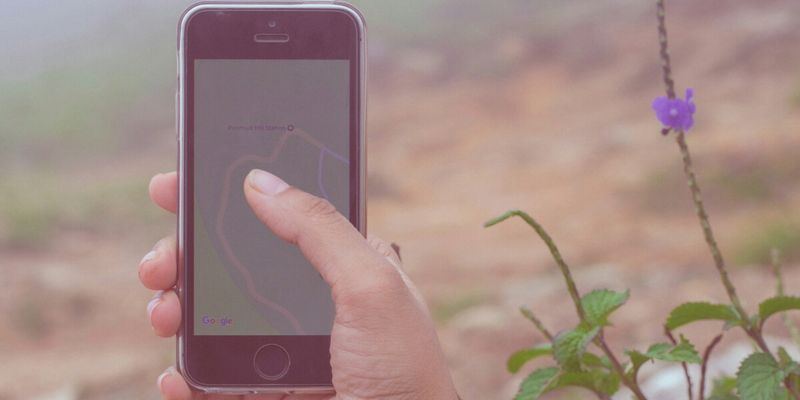 Traveler using eSIM on smartphone in Kerala tea plantation to stay connected