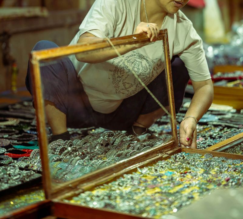 Night market stalls in North Goa selling hand-printed textiles and jewellery — the Saturday Night Market at Arpora runs October to April every week