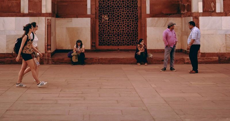 Traveler looking confused at phone on busy Indian street.