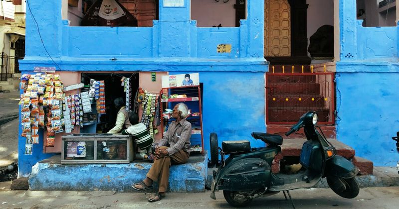 Man beside blue-painted storefront in Jodhpur Rajasthan — India 2 week itinerary Rajasthan