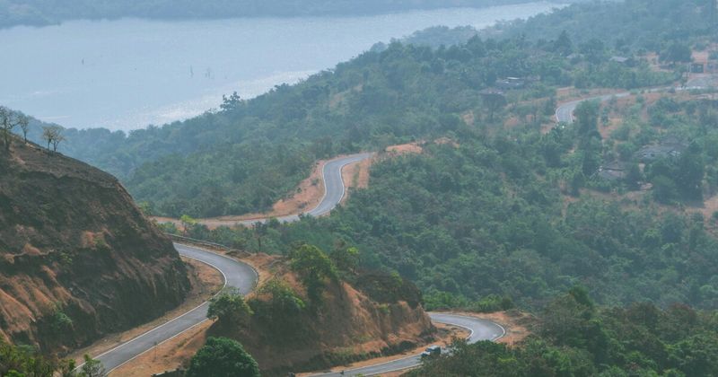 NH66 coastal highway winding through Konkan region between Mumbai and Goa — the scenic road trip route covers 570–600 km and takes 10–13 hours with stops