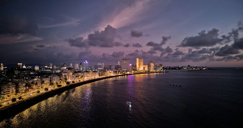 Marine Drive at night in Mumbai — the Queen's Necklace arc of streetlights earned its name from the view available from Malabar Hill; the 3.6-kilometre Art Deco promenade was built on reclaimed land in 1920 and is free to walk at any hour