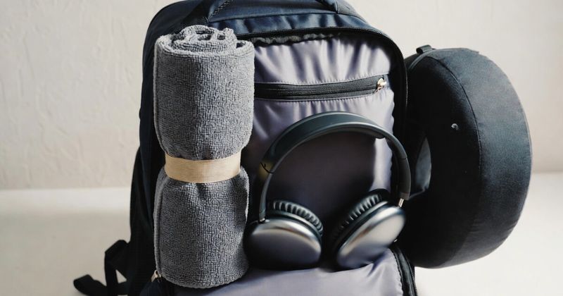 Packed travel backpack with microfiber towel and headphones