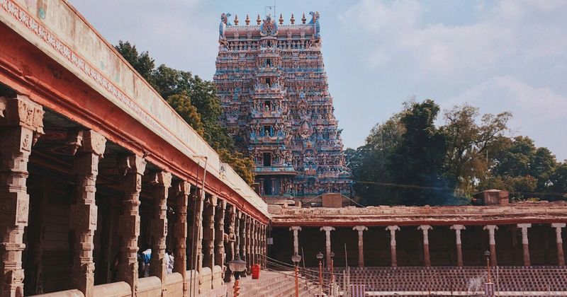 One of Meenakshi Amman Temple's 14 gopuram towers in Madurai, Tamil Nadu — each tower covered in approximately 33,000 individual hand-painted stucco sculptures, restored by a guild of shilpis sculptors every 12 years in the Kumbhabhishekam ceremony