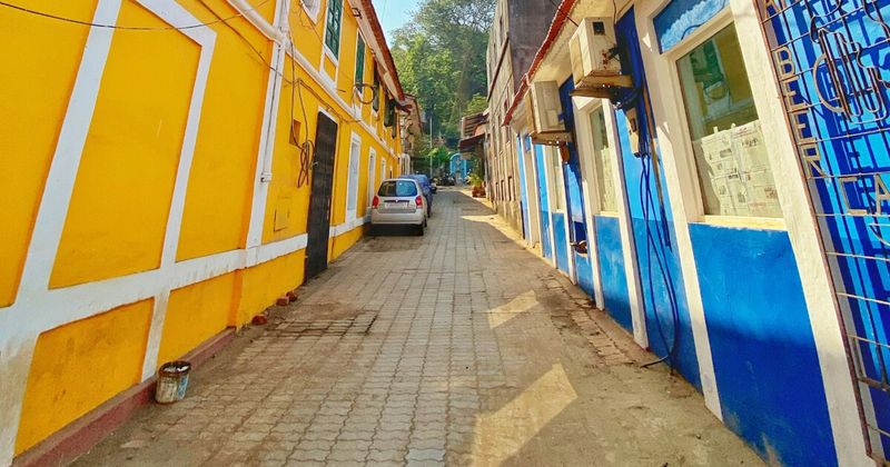 Narrow cobbled street in Fontainhas Panjim lined with yellow and blue Portuguese colonial houses — Goa beyond the beach itinerary