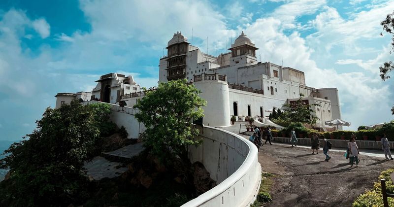 Sajjangarh Monsoon Palace on the Aravalli ridge above Udaipur at sunset — the 19th-century royal retreat at 944 metres offers the most complete panoramic view of Udaipur, Lake Pichola, and the surrounding Aravalli Hills; foreigners ₹200 + ₹80 vehicle, open until sunset