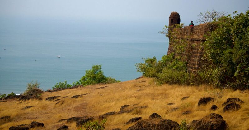 Golden hour view from Chapora Fort battlements above Vagator Beach in North Goa — a free-entry Portuguese fort that most visitors pass by in favour of the beach below
