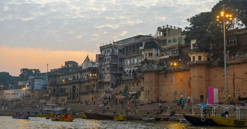 Varanasi's stone ghats at dawn — the Ganges, moored boats and temple spires in early mist — the definitive North India experience that rewards experienced travellers and overwhelms unprepared first-timers
