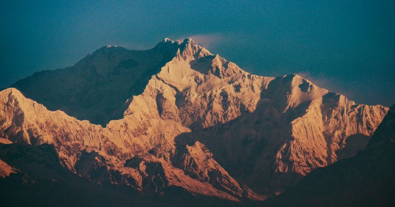 Kanchenjunga (8,586m) at sunrise from Tiger Hill, Darjeeling — the world's third-highest peak and Sikkim's sacred mountain; the Sikkimese prohibition on summiting the true peak is honoured by all expeditions; Tiger Hill sunrise entry ₹50 basic, ₹100 VIP; shared jeep departs ~3am from Darjeeling