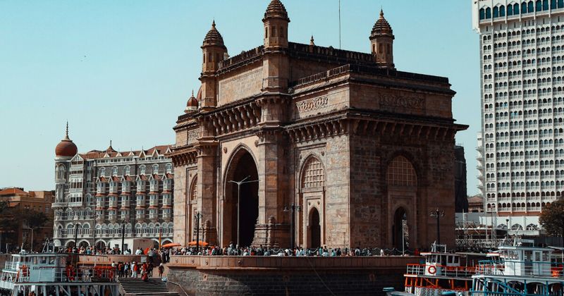 The Gateway of India on Mumbai's waterfront — built in 1924 to commemorate King George V's visit; the basalt arch is free to approach at any hour; the Taj Mahal Palace Hotel is visible immediately behind it; the harbour is the departure point for Elephanta Island ferries from 9am daily (closed Mondays)