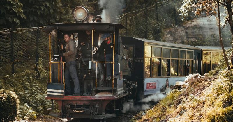 The Darjeeling Himalayan Railway steam engine on the narrow-gauge track — the UNESCO World Heritage railway built 1879–1881; Joy Ride diesel ₹805, steam ₹1,405; book on IRCTC; the 2-hour Darjeeling–Ghum–Batasia return trip includes a 30-minute stop at Ghum DHR Museum