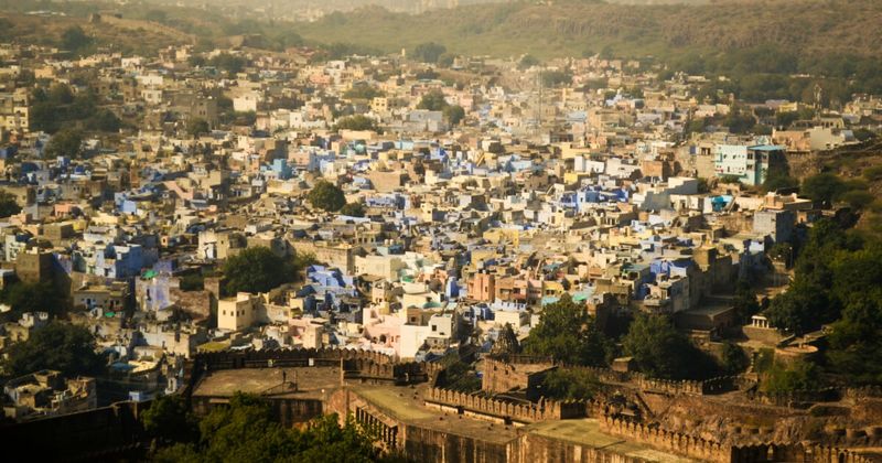 The Blue City of Jodhpur seen from Mehrangarh Fort's ramparts — the blue-washed houses of the old city were originally associated with the Brahmin caste's indigo-painted homes; a maharaja's decree in the 1960s spread the colour city-wide for tourism, making the colour universal and inadvertently erasing its original social meaning