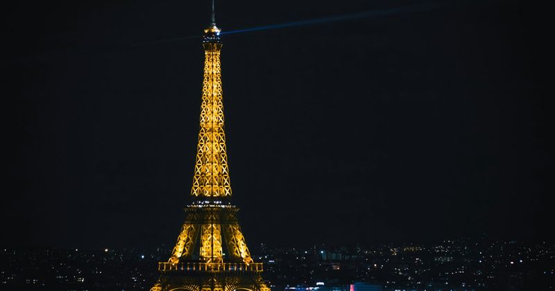 Paris Eiffel Tower at night — France to India flights 2026 direct vs Gulf layover.